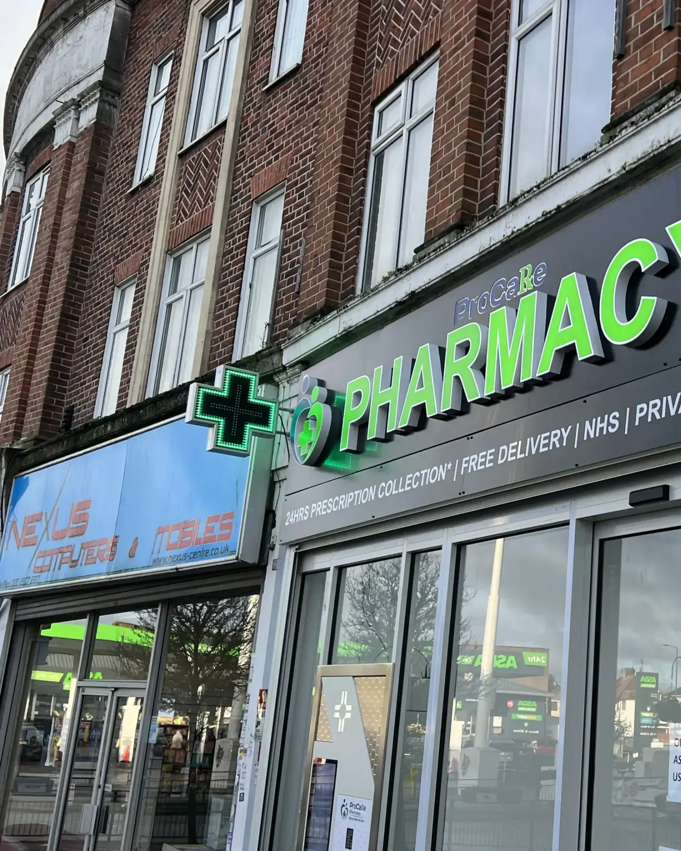 Pharmacy fascia with illuminated letters and a round projecting cross sign