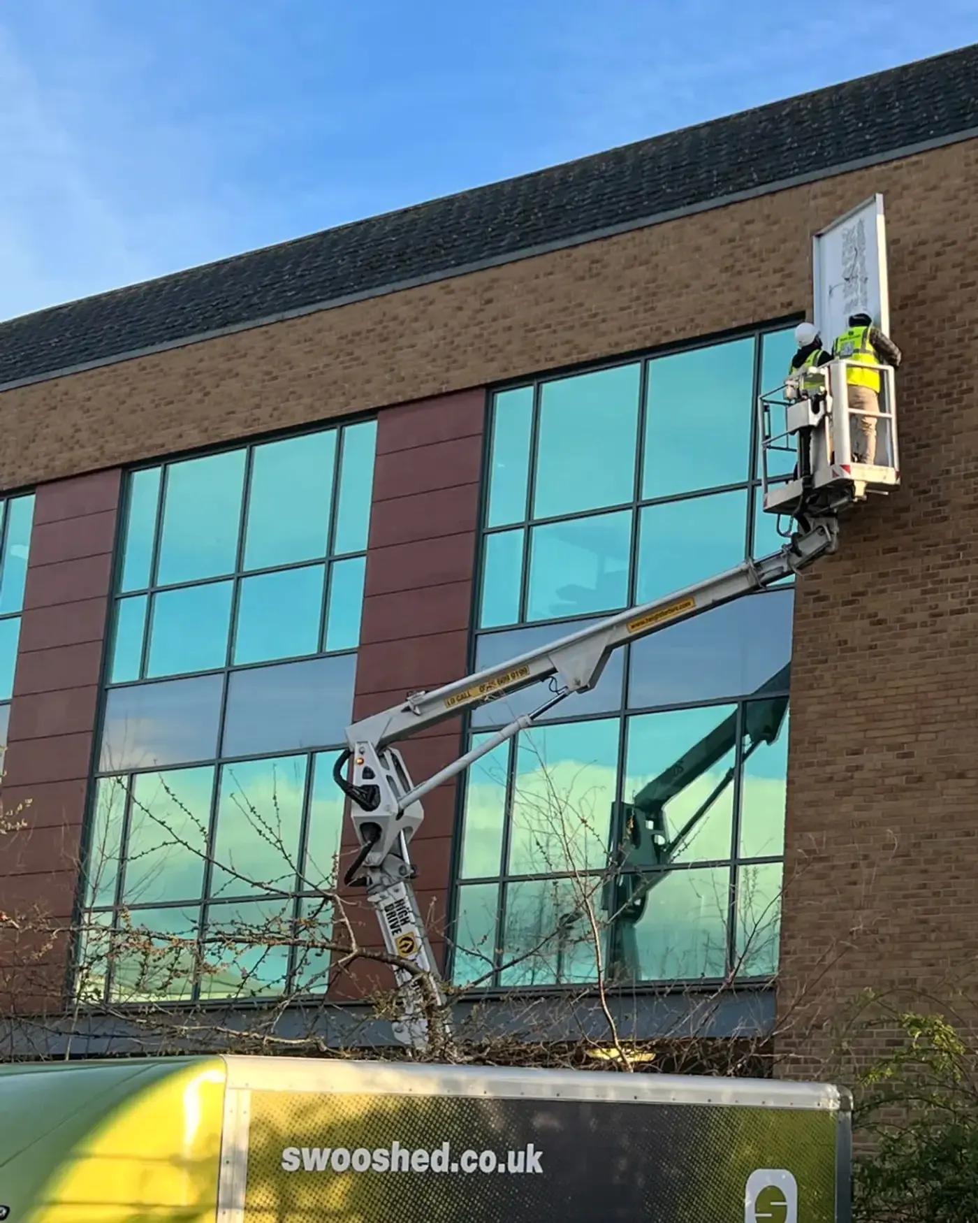 Sign Group installers working from a cherry picker at Euro Exim Bank, Borehamwood