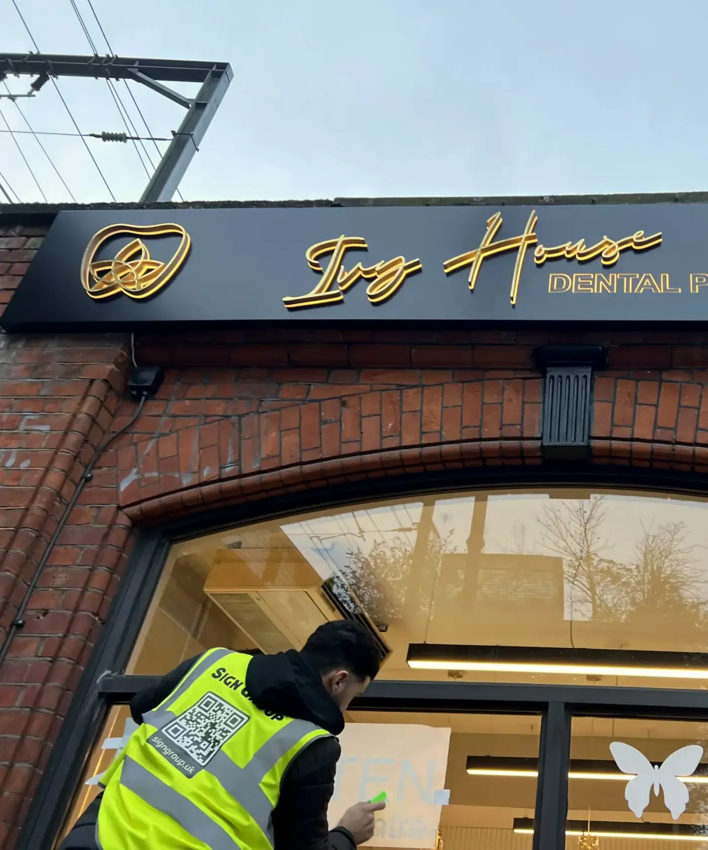 Sign Group fitter installing signage at Ivy House Dental, Camden