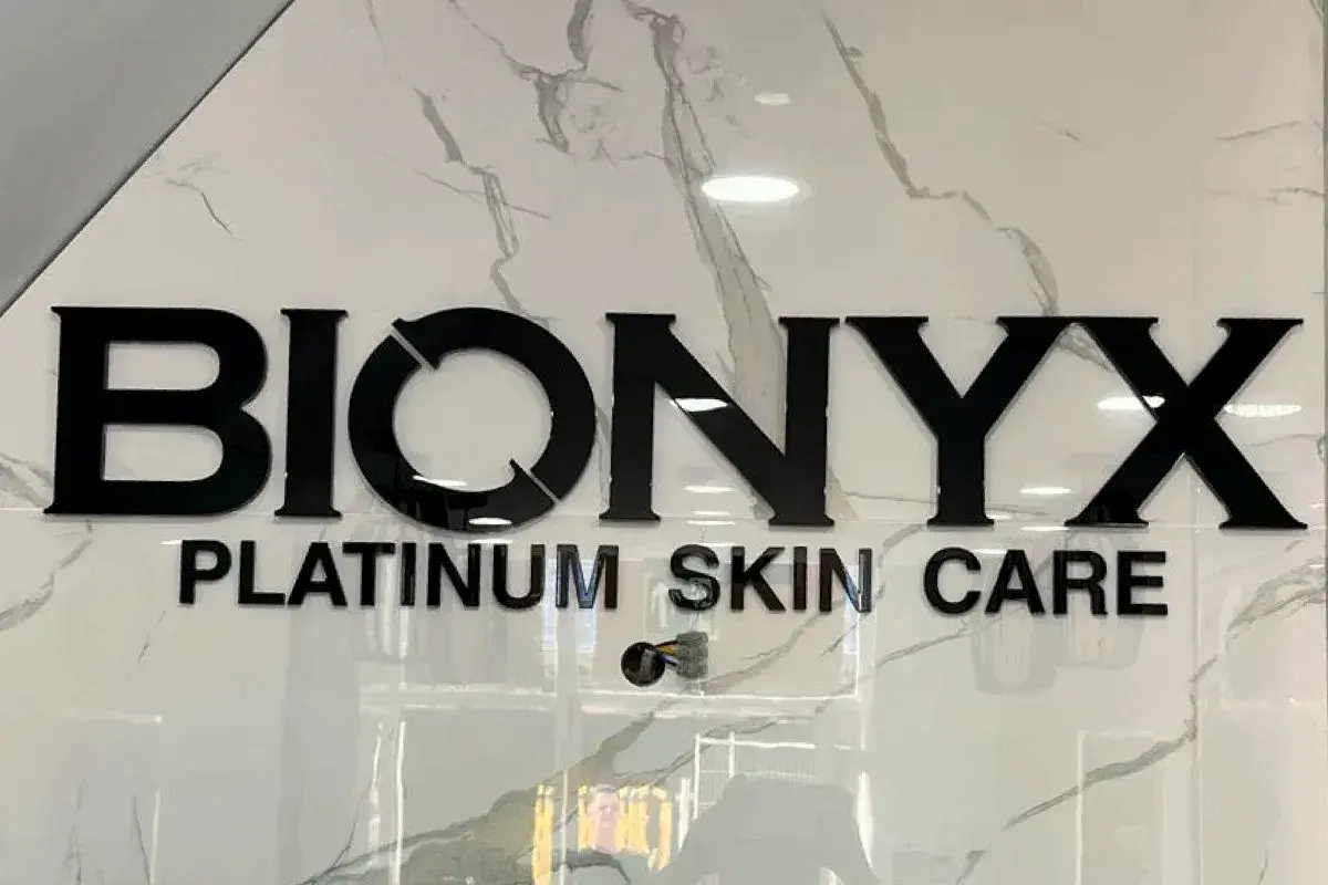 Black acrylic Bionyx Platinum Skin Care letters on a marble wall inside the shop