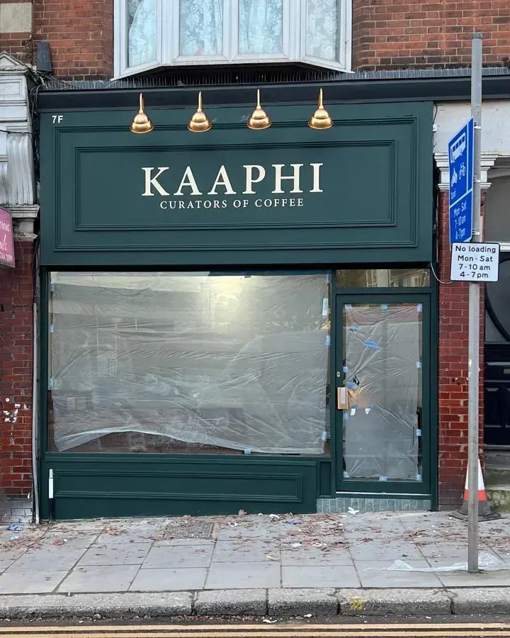 Kaaphi shop front: painted timber fascia with a moulded panel frame and raised gold-finish letters