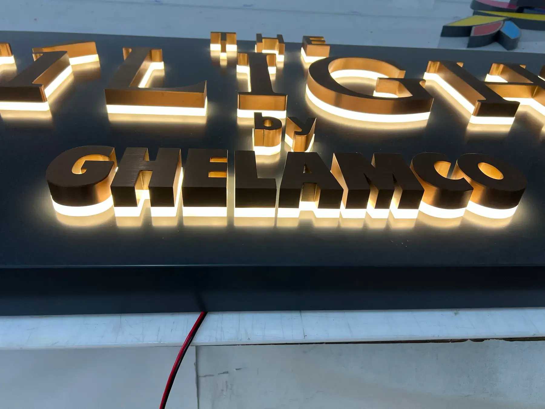 Close-up of the halo-lit rose gold Ghelamco letters, showing the brushed stainless steel faces and returns