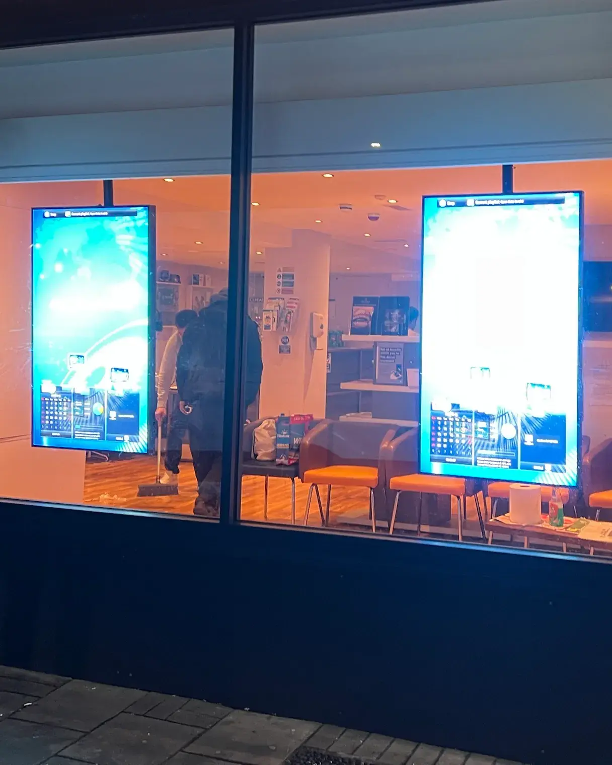 Two ultra-bright LED window screens in the window of Tigga Smile Bedford at night