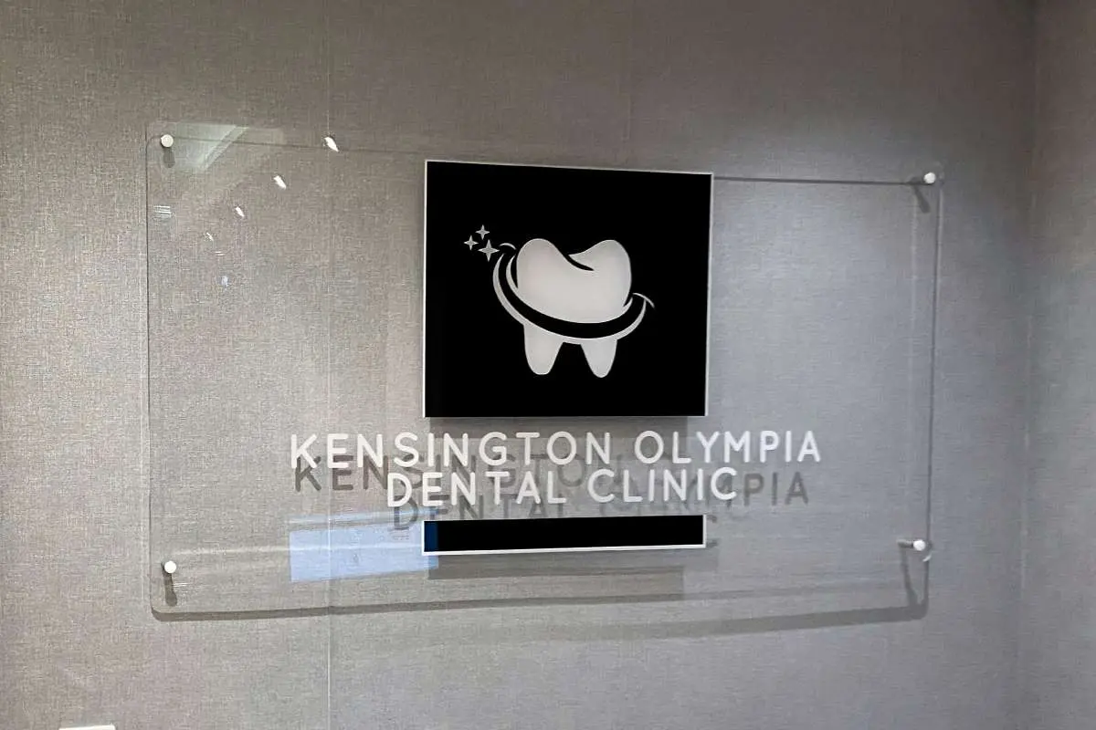 Clear acrylic Kensington Olympia Dental Clinic panel fixed off the wall on stand-offs